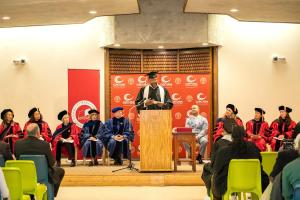 A graduate speaks in front of the academic assembly during the commencement ceremony.